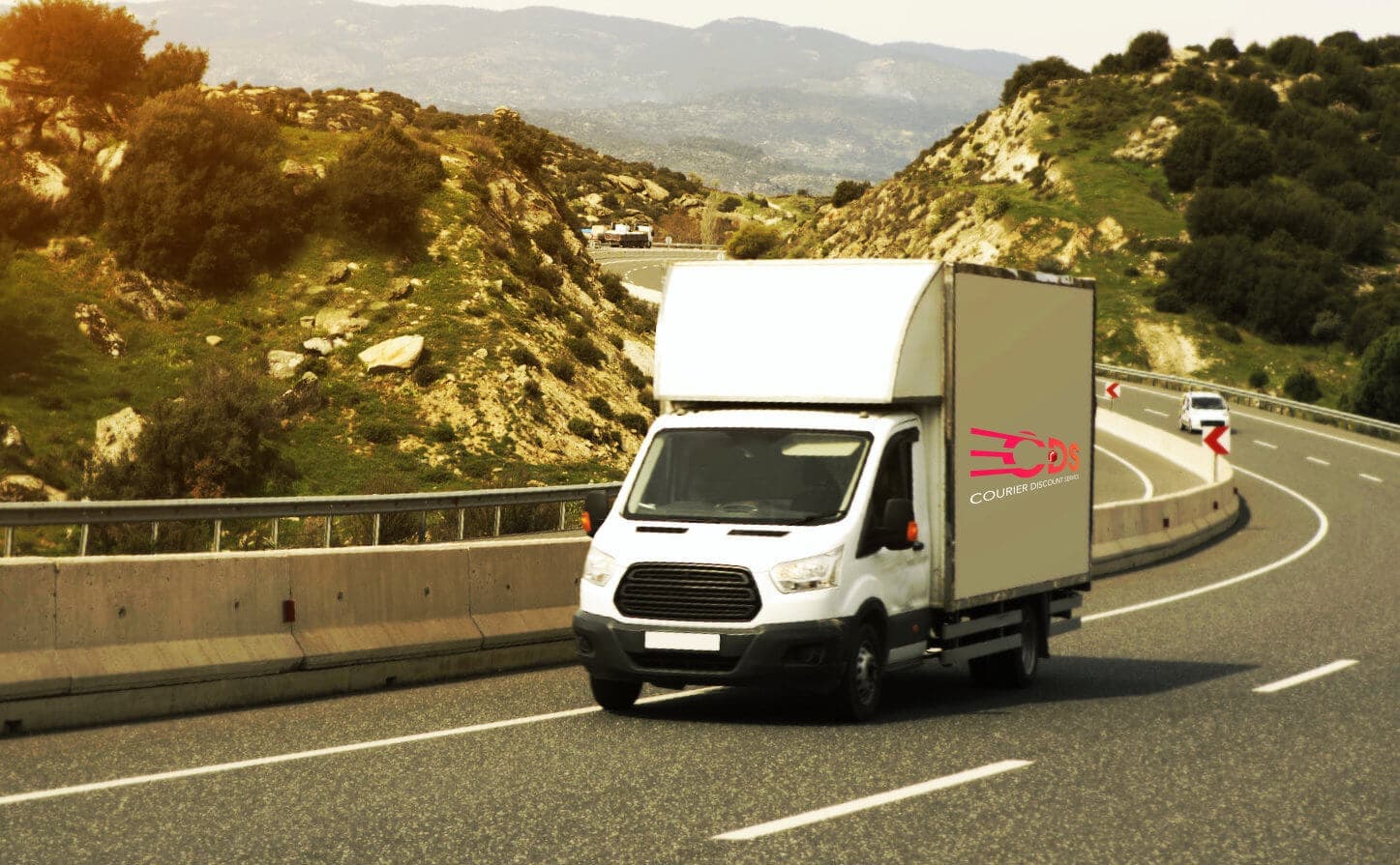 white truck driving through side of a road